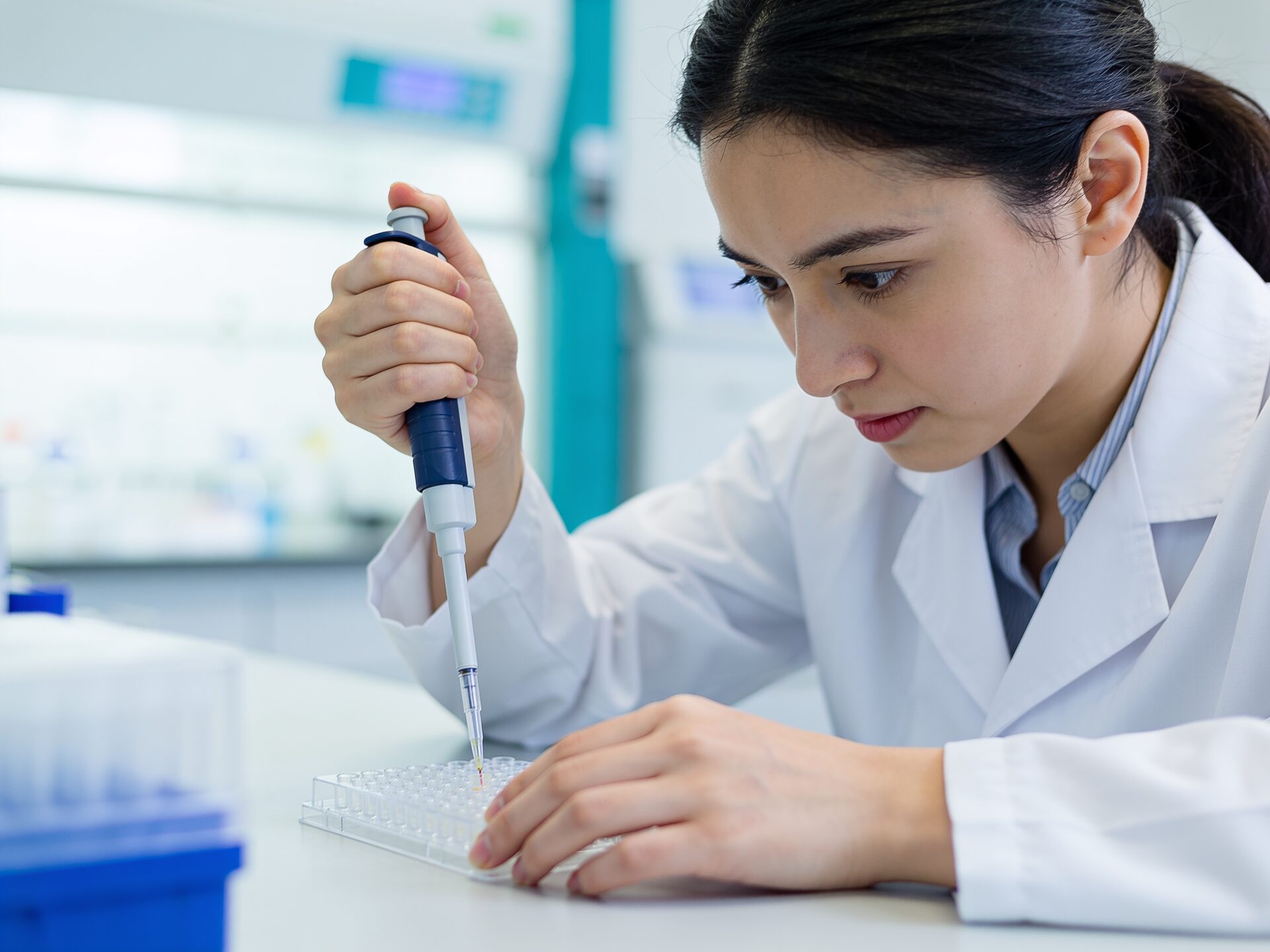 A scientist pipetting samples in a modern genomics laboratory